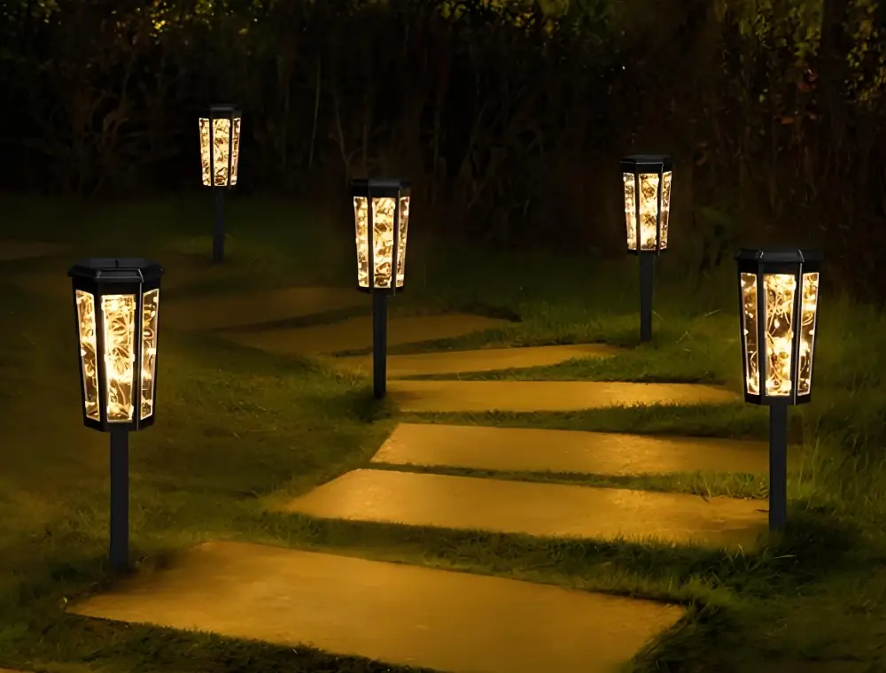 Outdoor path lights installed beside a landscaped walkway at night