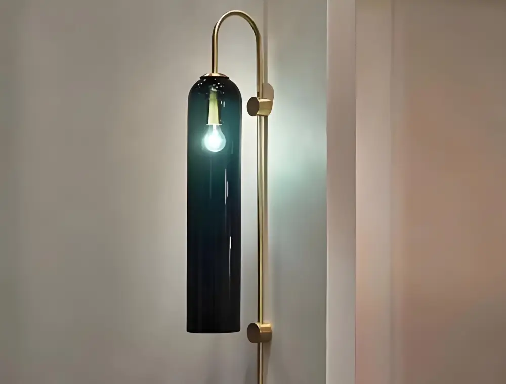 Slim decorative wall light with dark body and brass-coloured mounting arm
